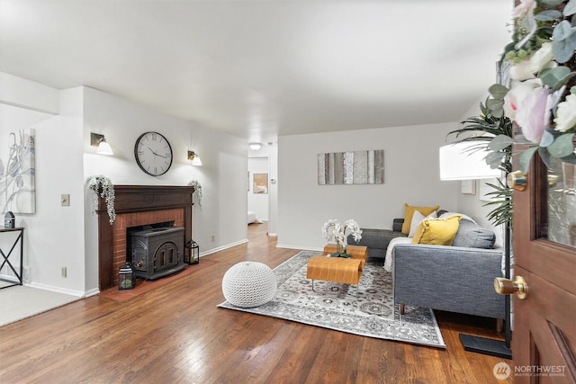 2607 NE 137th St, Seattle, WA 98125 - living room featuring a wood stove, wood finished floors, and baseboards