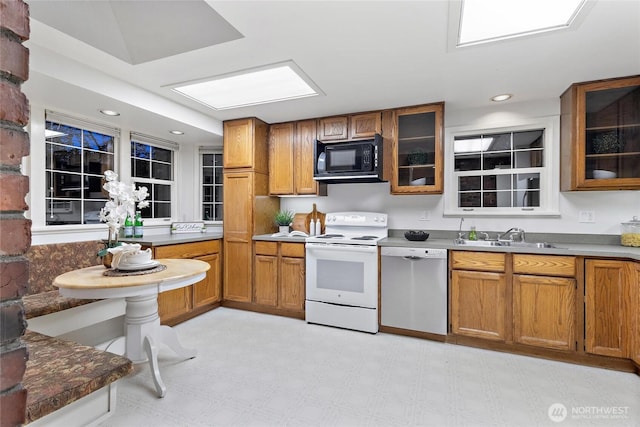 2607 NE 137th St, Seattle, WA 98125 - kitchen with dishwasher, white range with electric cooktop, black microwave, a sink, and brown cabinetry
