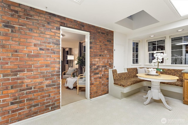 2607 NE 137th St, Seattle, WA 98125 - dining room featuring tile patterned floors, breakfast area, brick wall, and baseboards