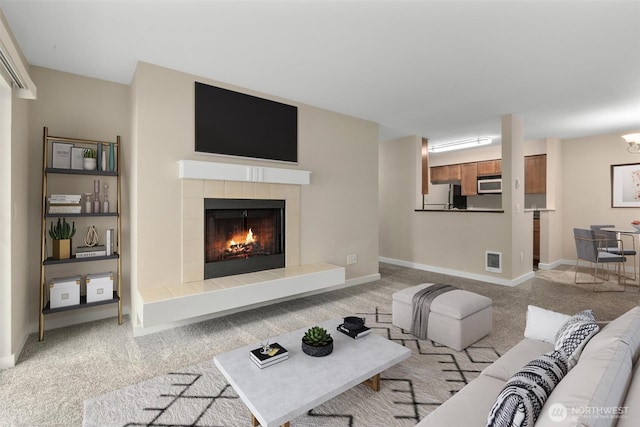 12303 Harbour Pointe Blvd Unit U109, Mukilteo, WA 98275 - living room featuring a tiled fireplace, light carpet, and baseboards