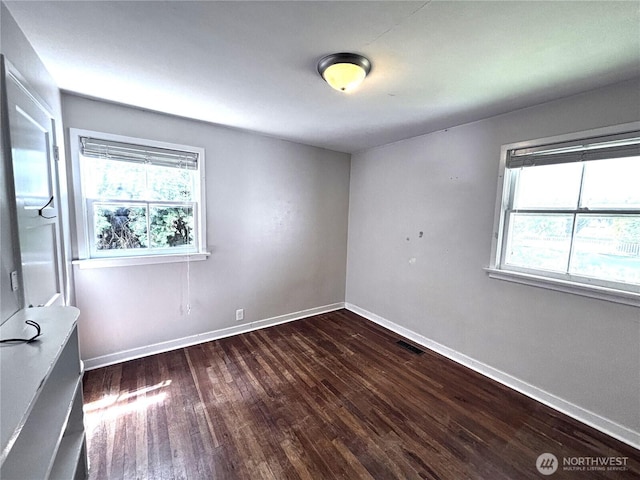 711 Guernsey St, Prosser, WA 99350 - spare room featuring dark wood-style floors, plenty of natural light, and baseboards