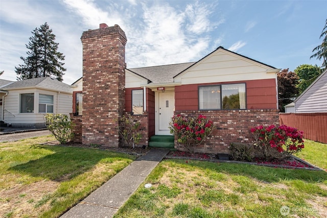 bungalow featuring a chimney and brick siding