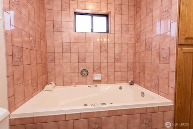 bathroom featuring a garden tub and toilet
