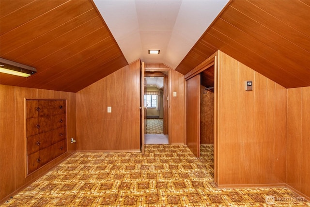 bonus room with wooden walls, lofted ceiling, and carpet floors