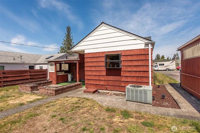 back of property with central AC and fence