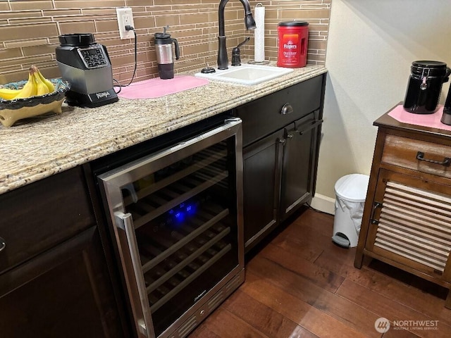 2702 N Levi St, Kennewick, WA 99338 - bar area featuring wine cooler, a sink, decorative backsplash, dark wood-style floors, and baseboards