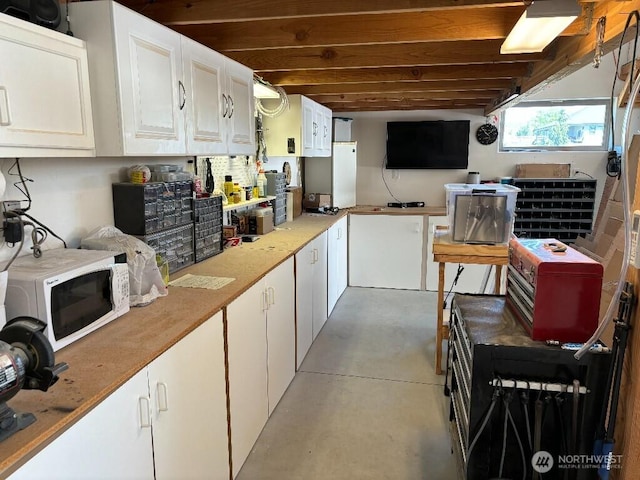 2702 N Levi St, Kennewick, WA 99338 - kitchen featuring white microwave, concrete flooring, white cabinetry, and light countertops