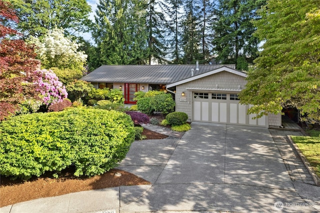 12211 SE 65th Pl, Bellevue, WA 98006 - view of front of house featuring an attached garage, concrete driveway, and metal roof