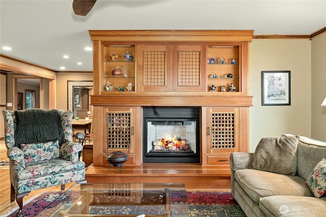 12211 SE 65th Pl, Bellevue, WA 98006 - living area featuring crown molding, a glass covered fireplace, wood finished floors, and recessed lighting