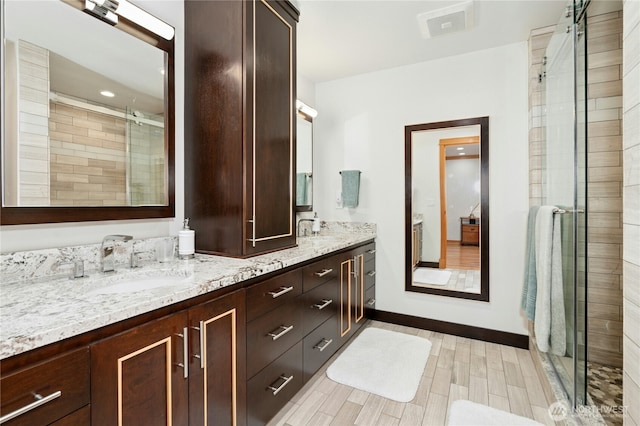 12211 SE 65th Pl, Bellevue, WA 98006 - bathroom featuring double vanity, a stall shower, baseboards, and wood finished floors