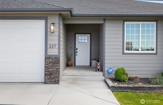 227 N Crestview Dr, Moses Lake, WA 98837 - entrance to property featuring roof with shingles, an attached garage, concrete driveway, and stone siding