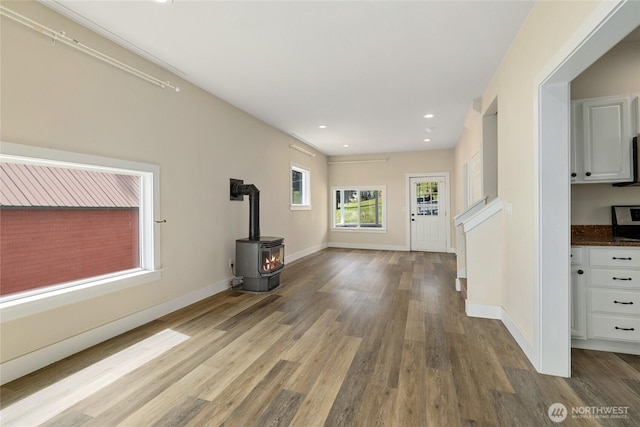 511 S 2nd St, Roslyn, WA 98941 - unfurnished living room featuring a wood stove, wood finished floors, baseboards, and recessed lighting