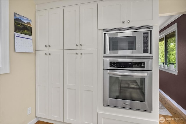 245 SW 298th Pl, Federal Way, WA 98023 - kitchen with appliances with stainless steel finishes, baseboards, wood finished floors, and white cabinets