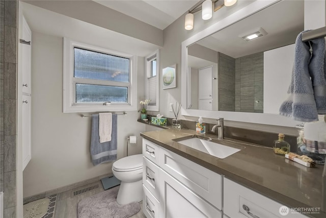 245 SW 298th Pl, Federal Way, WA 98023 - bathroom featuring vanity, toilet, baseboards, and tiled shower