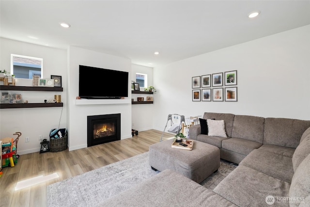 12605 179th St E, Puyallup, WA 98374 - living room featuring wood finished floors, a glass covered fireplace, recessed lighting, and baseboards