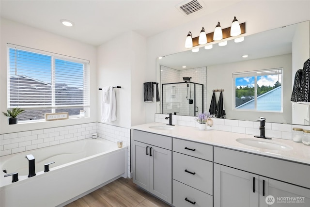 12605 179th St E, Puyallup, WA 98374 - bathroom featuring a shower stall, a garden tub, double vanity, wood finished floors, and recessed lighting