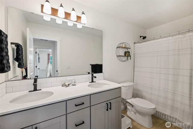 12605 179th St E, Puyallup, WA 98374 - full bath featuring double vanity, toilet, a shower with shower curtain, and wood finished floors