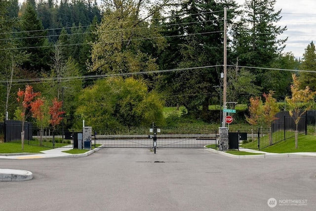 2076 Crystal Mountain Dr Unit 89, Enumclaw, WA 98022 - view of asphalt road featuring a gate, curbs, traffic signs, and a gated entry