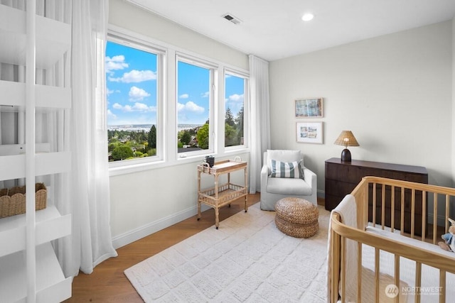 3727 W Barrett St, Seattle, WA 98199 - bedroom featuring wood finished floors, multiple windows, baseboards, recessed lighting, and a nursery area