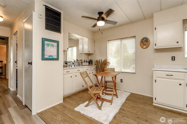dining space with ceiling fan, light wood-style floors, and baseboards