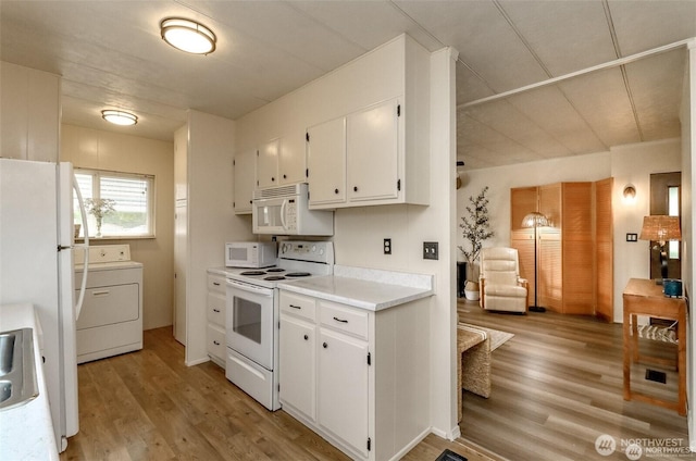 kitchen featuring white appliances, washer / dryer, light wood finished floors, white cabinetry, and light countertops
