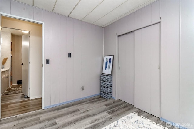 unfurnished bedroom featuring light wood finished floors and a closet