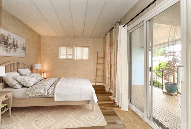 bedroom with wood finished floors and access to exterior