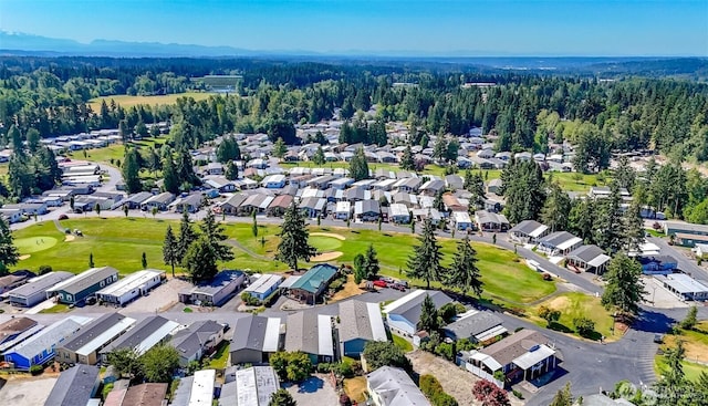 aerial view of residential area featuring a golf club and a heavily wooded area