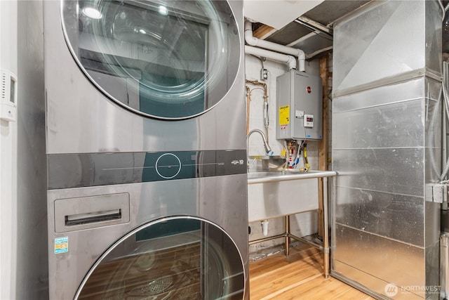 6026 35th Ave NE, Seattle, WA 98115 - washroom featuring stacked washer / dryer, water heater, and wood finished floors