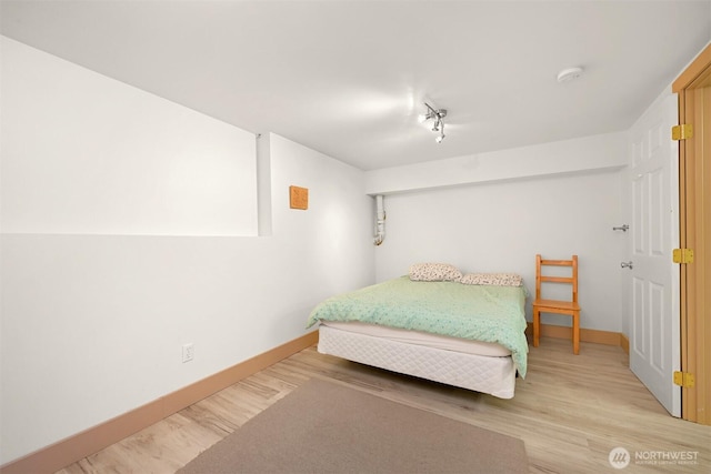 7117 Rainier Way, Deming, WA 98244 - bedroom with baseboards, wood finished floors, and rail lighting