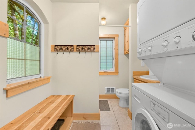 7117 Rainier Way, Deming, WA 98244 - full bath featuring stacked washer and clothes dryer, toilet, tile patterned flooring, and baseboards