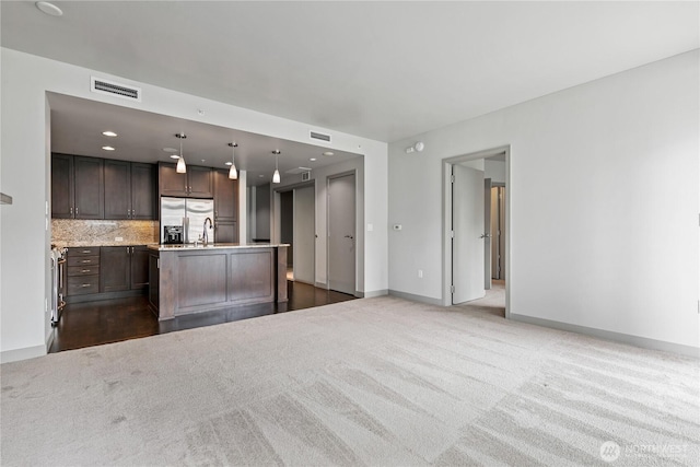 unfurnished living room featuring baseboards, dark colored carpet, and recessed lighting