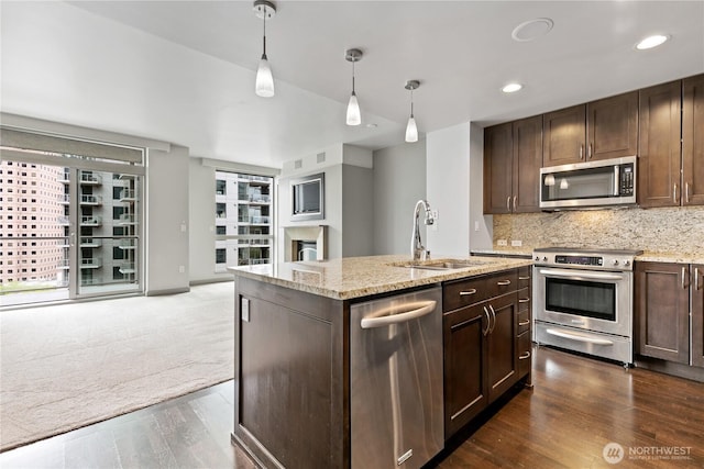 kitchen featuring stainless steel appliances, a sink, dark wood-style flooring, dark brown cabinets, and recessed lighting