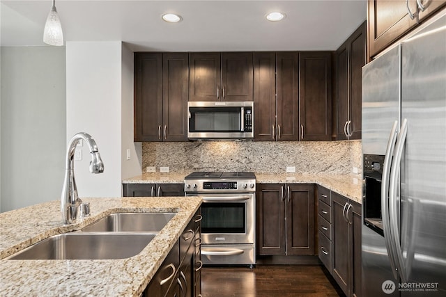 kitchen featuring appliances with stainless steel finishes, a sink, dark wood-style floors, recessed lighting, and dark brown cabinetry