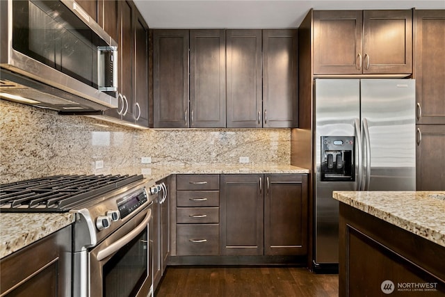 kitchen with appliances with stainless steel finishes, dark wood-type flooring, dark brown cabinets, and decorative backsplash