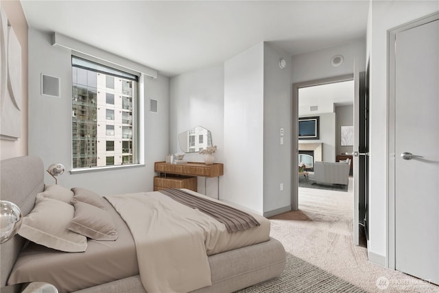 bedroom with carpet flooring and a fireplace