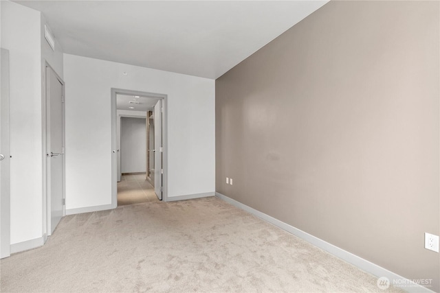 unfurnished bedroom featuring light colored carpet and baseboards
