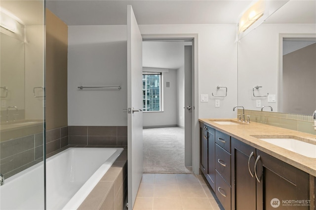 full bathroom with tile patterned flooring, tiled bath, and double vanity