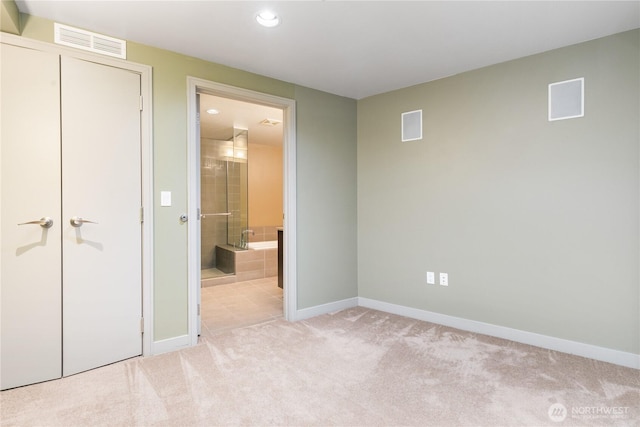 unfurnished bedroom featuring baseboards, recessed lighting, light colored carpet, and ensuite bath