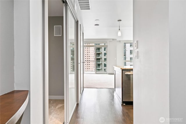 hallway with dark wood finished floors, dark colored carpet, and baseboards
