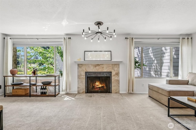 132 N 132nd Unit 202, Seattle, WA 98133 - carpeted living area with a chandelier, a textured ceiling, plenty of natural light, and a fireplace