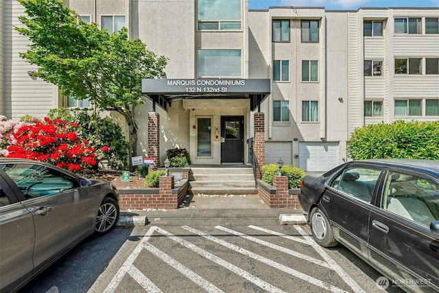 132 N 132nd Unit 202, Seattle, WA 98133 - view of exterior entry featuring uncovered parking and stucco siding