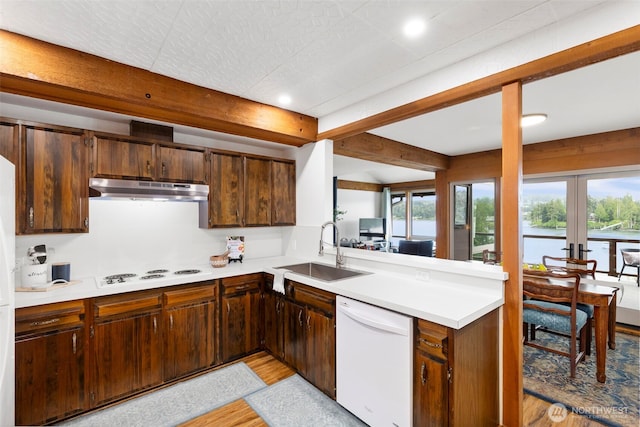 131 N Bay Ln Unit 4, Port Ludlow, WA 98365 - kitchen with white appliances, under cabinet range hood, a sink, french doors, and light wood-type flooring