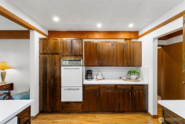 131 N Bay Ln Unit 4, Port Ludlow, WA 98365 - kitchen featuring white double oven, light countertops, light wood-type flooring, and recessed lighting