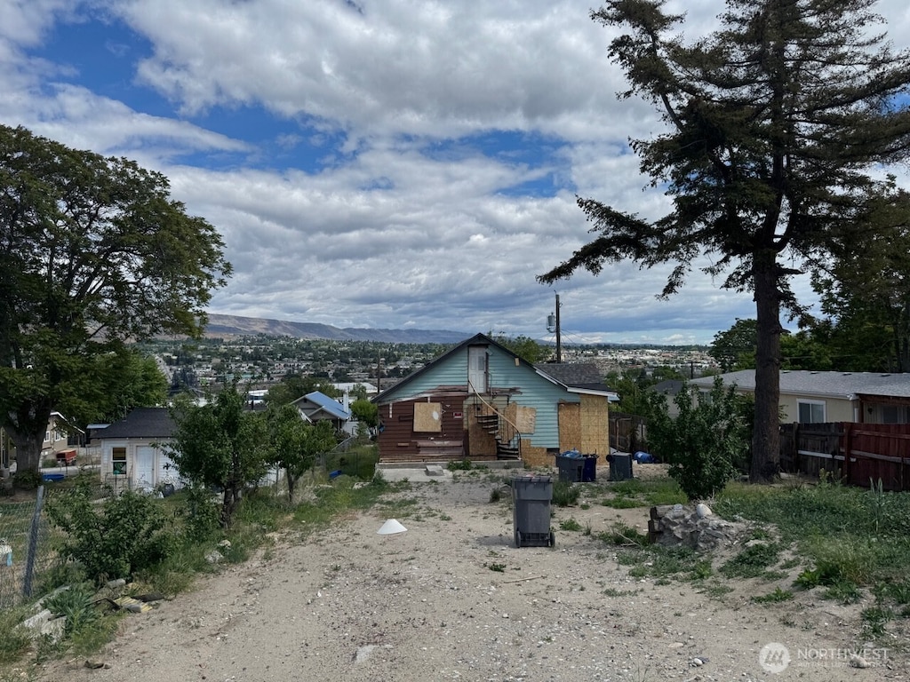 816 S Chelan Ave, Wenatchee, WA 98801 - back of house with fence, a mountain view, and driveway