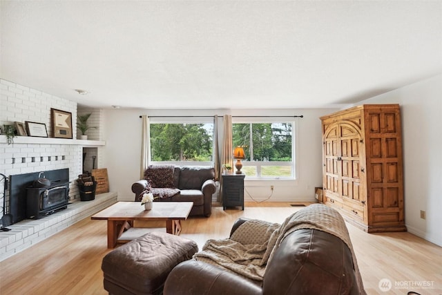 3512 Frances Dr SE, Lacey, WA 98503 - living area featuring light wood-style flooring, a wood stove, and baseboards