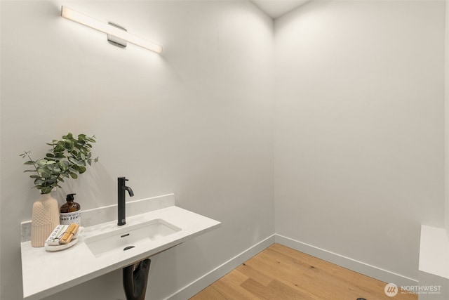 1108C 34th Ave, Seattle, WA 98122 - laundry room featuring a sink, light wood finished floors, and baseboards