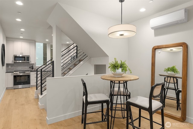 1108C 34th Ave, Seattle, WA 98122 - dining room with a wall mounted air conditioner, light wood finished floors, stairway, recessed lighting, and baseboards