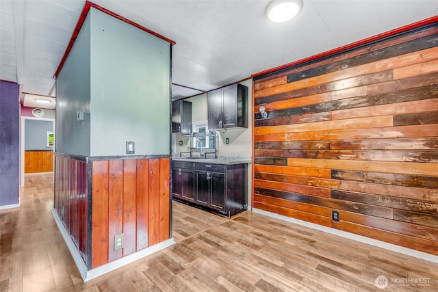 7311 Chambers Creek Rd W Unit 37, University Place, WA 98467 - kitchen with wooden walls, light wood-style flooring, a wainscoted wall, stone counters, and a sink