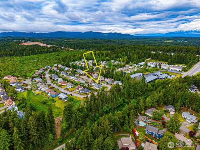 7819 Amethyst Loop NW, Silverdale, WA 98383 - aerial overview of property's location with a forest, a mountain backdrop, and nearby suburban area